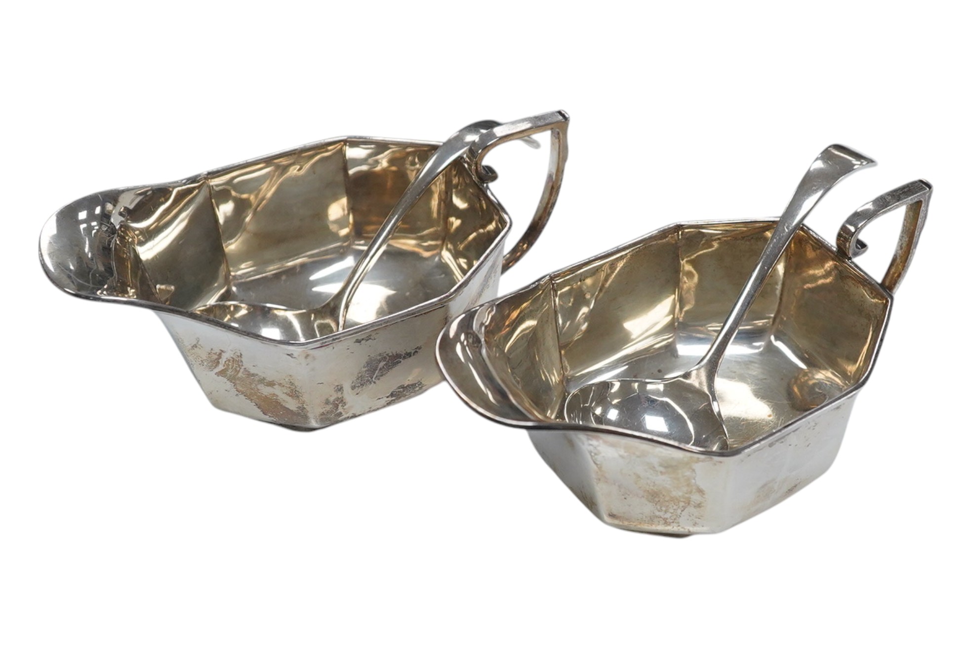 A pair of George V silver sauceboats, Henry Clifford Davies, Birmingham, 1936, length 13.4cm, together with a later pair of sauce ladles by Cooper Brothers & Sons, 9.1oz. Condition - fair to good